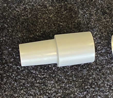 A white pipe sitting on top of the carpet.