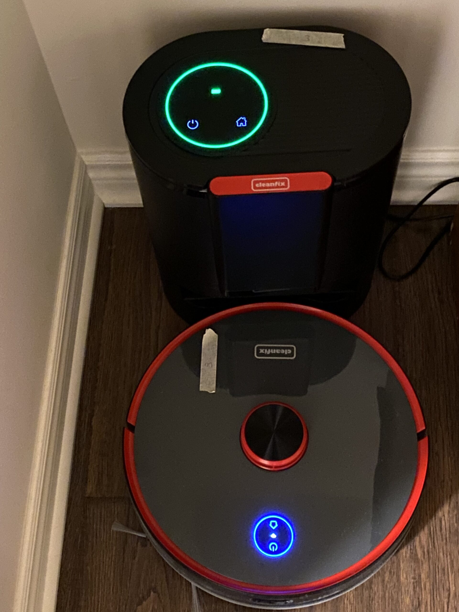 A black and red robot vacuum next to each other.